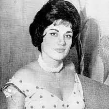 A black and white photo of a woman in a polka dot dress.