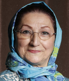 A woman with glasses and a blue head scarf.