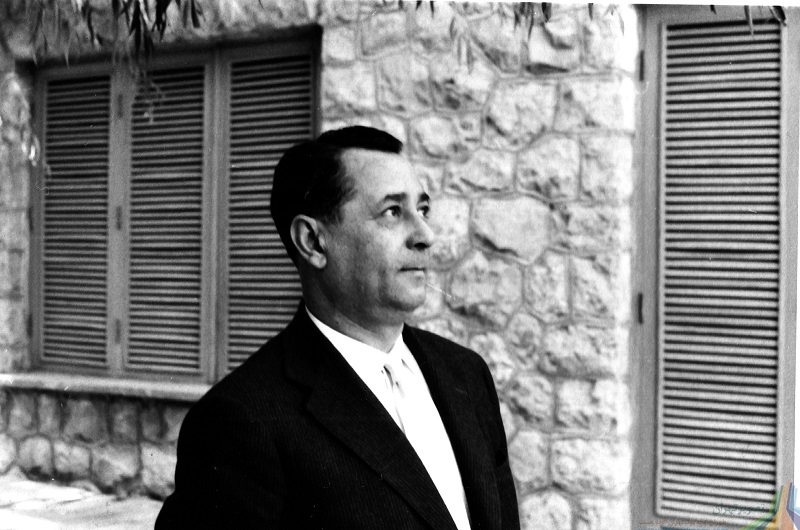 A man in suit and tie standing outside.