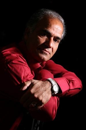 A man in red shirt leaning on his arm.