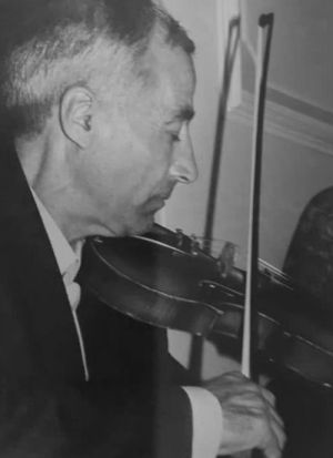 A man playing the violin in black and white.
