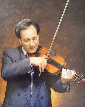 A man in a suit and tie playing the violin.