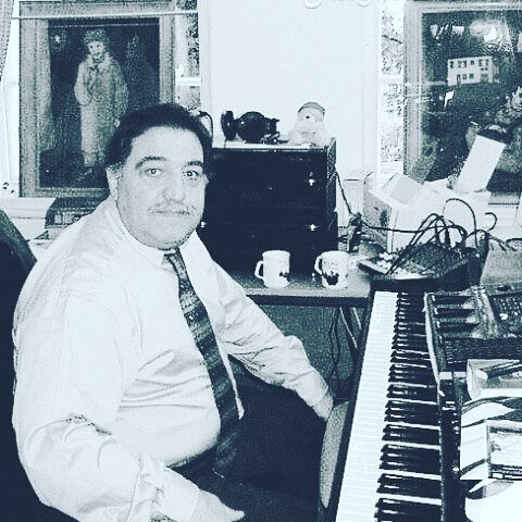 A man sitting at the piano in his office.