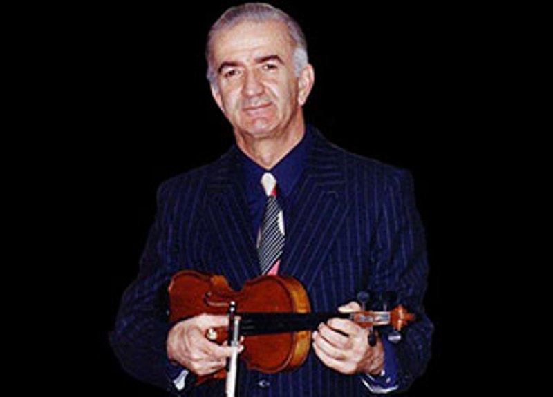A man in a suit and tie holding a violin.